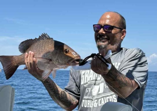 Guest with a mangrove snapper caught on a Rising Tide charter