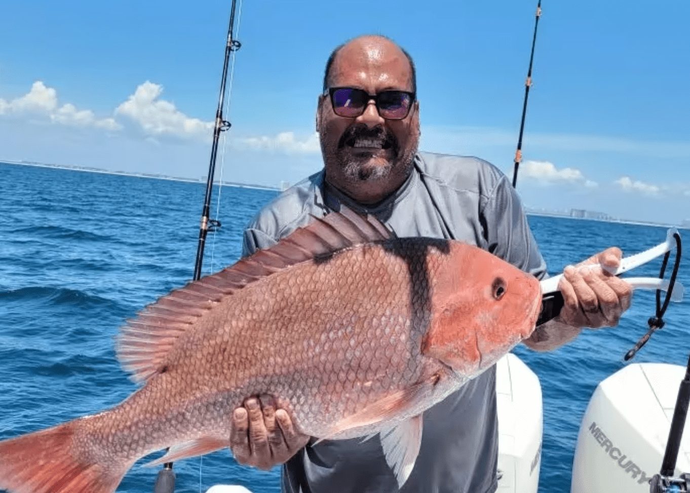 Guest holding a large red snapper on the Gulf of Mexico