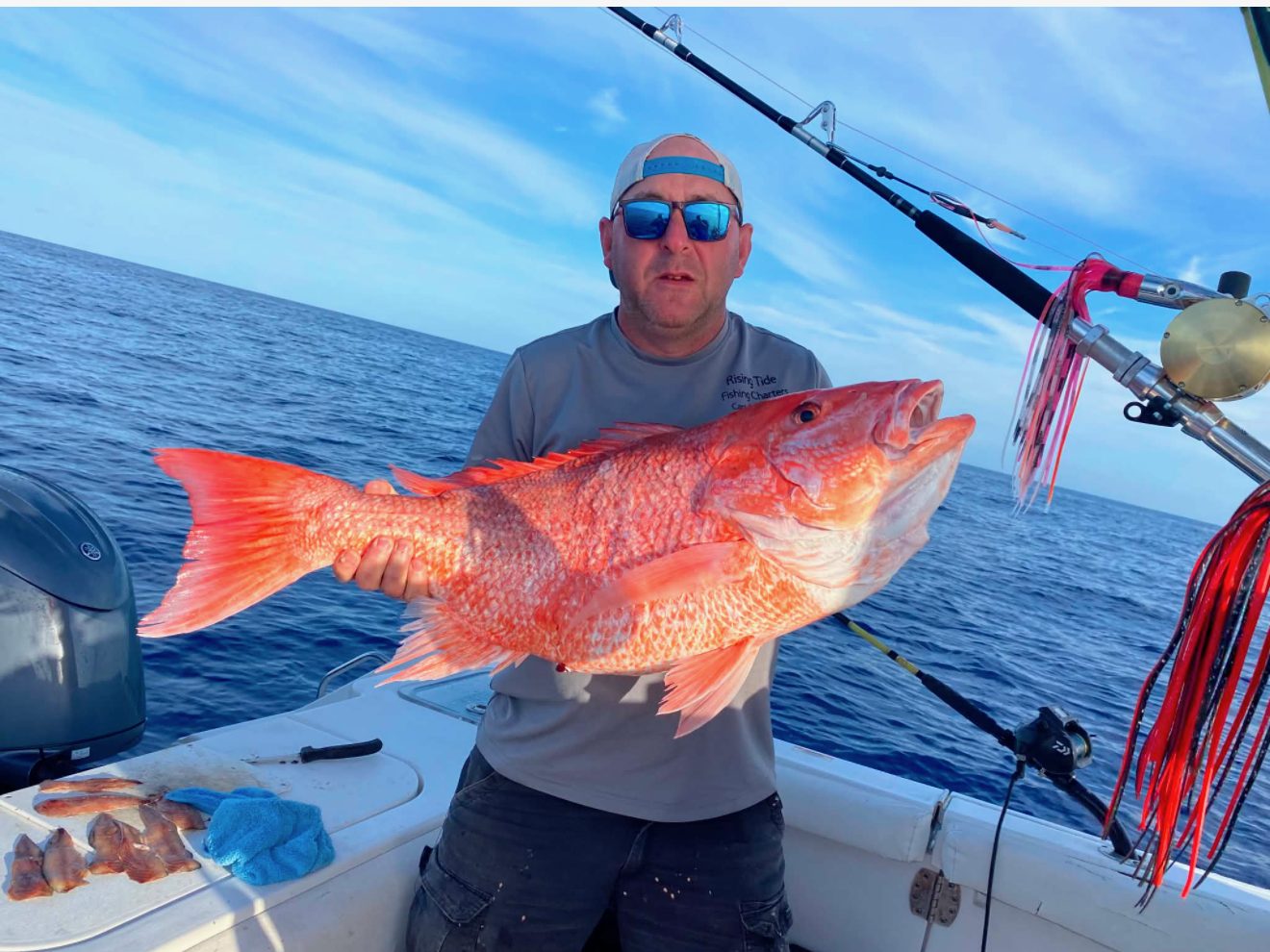 Angler holding a large red snapper aboard Rising Tide off Panama City