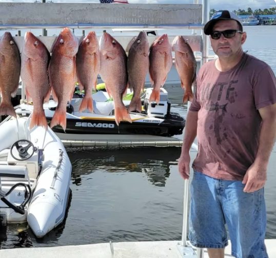 Two anglers with a haul of red snapper at the dock